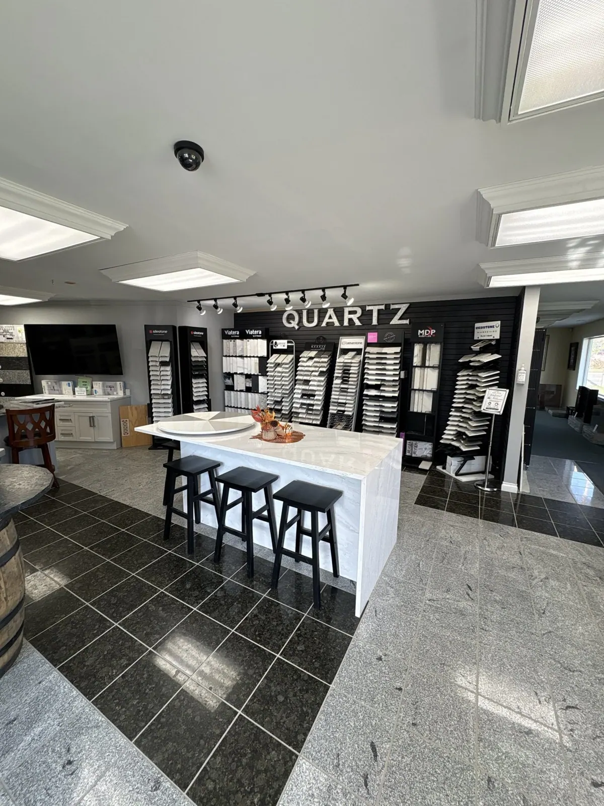 Inside our showroom: a quartz waterfall island in front of a wall of quartz samples